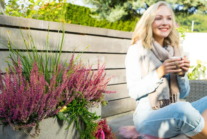Frau auf Bank mit Gardengirls im Kübel
