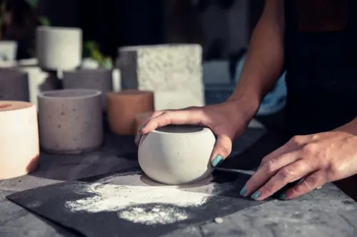 Nahaufnahme von Sandpapier und einer Vase aus Beton