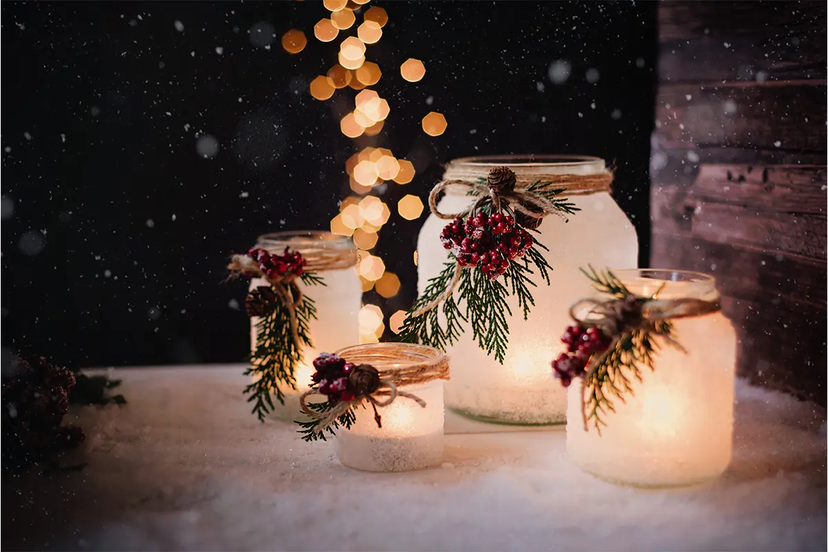 Windlicht basteln Weihnachten mit Sprühschnee, Beeren und Grün [Foto: AdobeStock_Emmi]