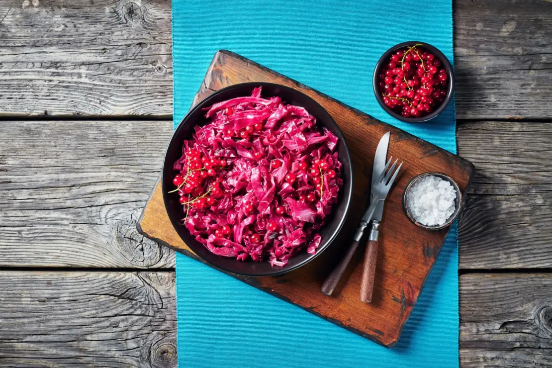 Zu sehen ist ein Teller aus der Vogelperspektive, der gefüllt ist mit Rotkohl und Johannisbeeren.