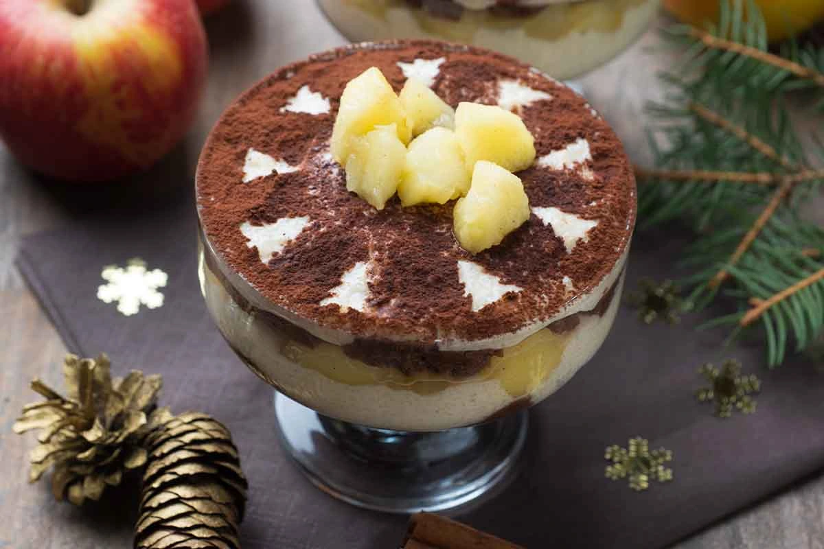 Bratapfel-Tiramisu im Glas mit Apfelwuerfeln und Kakaopulver garniert [Foto: AdobeStock_Kitty]