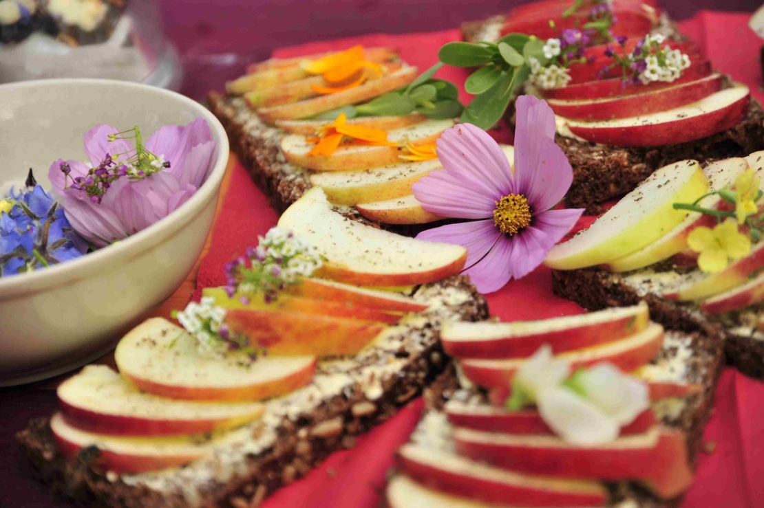 Essbare Blüten auf einem Brot mit Apfelschnitzen