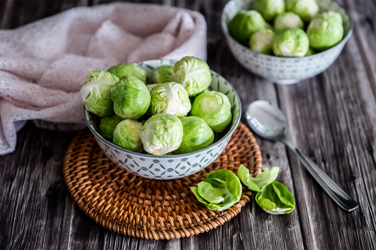 Rosenkohl in einem kleinen Schälchen auf einem Holztisch [Foto: AdobeStock_PicsArt]