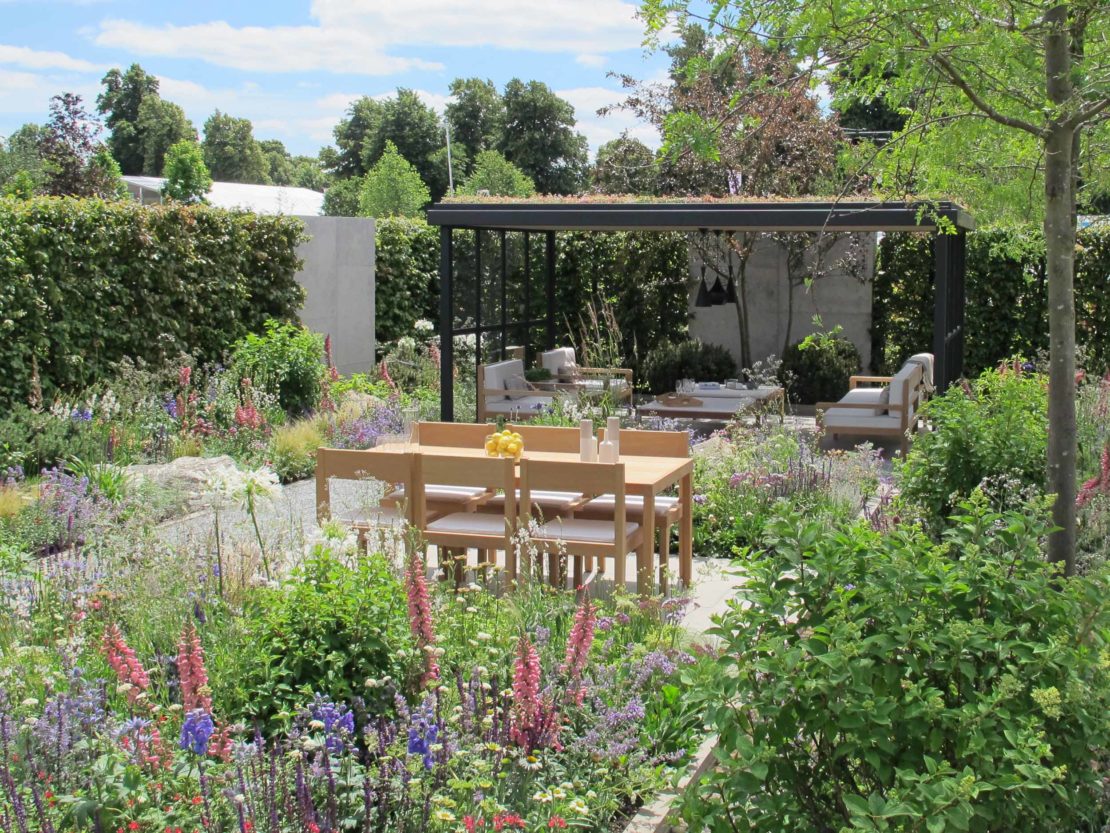 Viele blühende Stauden und ein schlichter Gartenpavillon lassenn den Lagom-Garten sehr natürlich wirken.