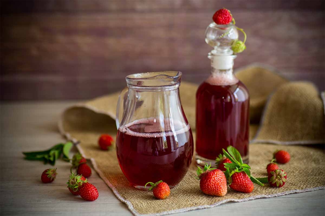 Erdbeersirup in einer Kanne und in einer Flasche [Foto: AdobeStock_Peredniankina]