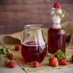 Erdbeersirup in einer Kanne und in einer Flasche [Foto: AdobeStock_Peredniankina]