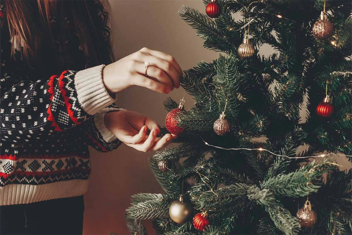 Hier wird ein Weihnachtsbaum geschmueckt [Foto: AdobeStock_Sonyachny]