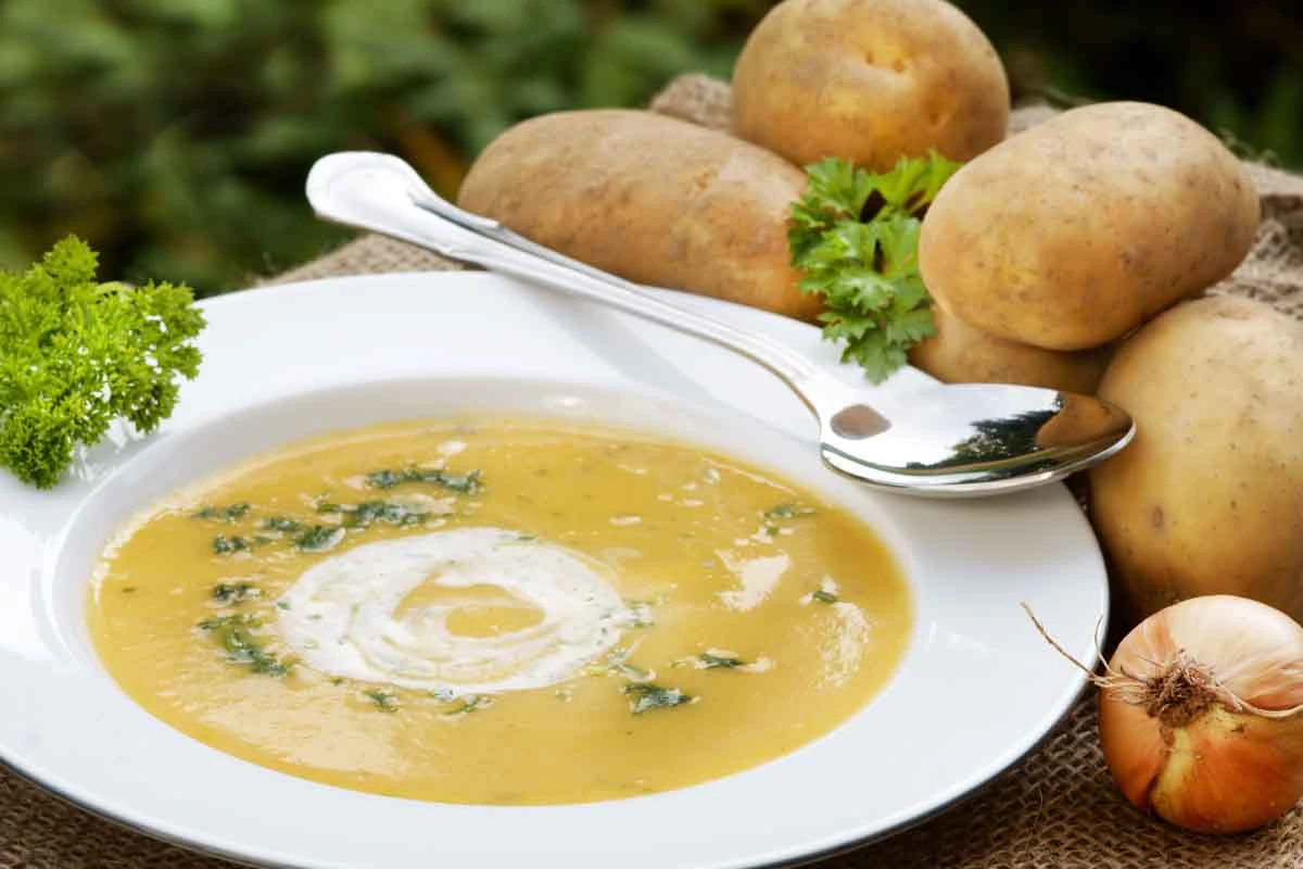 Kartoffelsuppe neben Kartoffeln und Petersilie [Foto: AdobeStock_Johanna Mühlbauer]