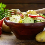 Schneller Kartoffelsalat mit Radieschen, Senf und Gurke in einer Schale [Foto: AdobeStock_Olga Kriger]