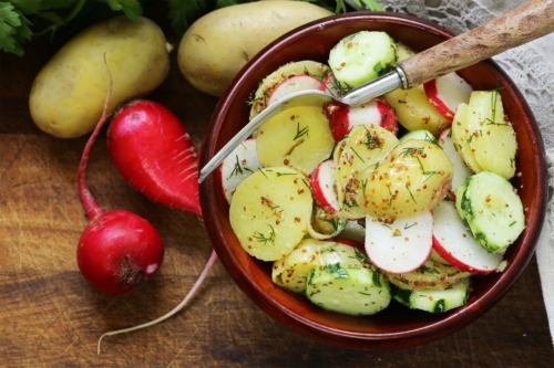 Schneller Kartoffelsalat mit Radieschen und Gurke in einer Schale [Foto: AdobeStock_Olga Kriger]