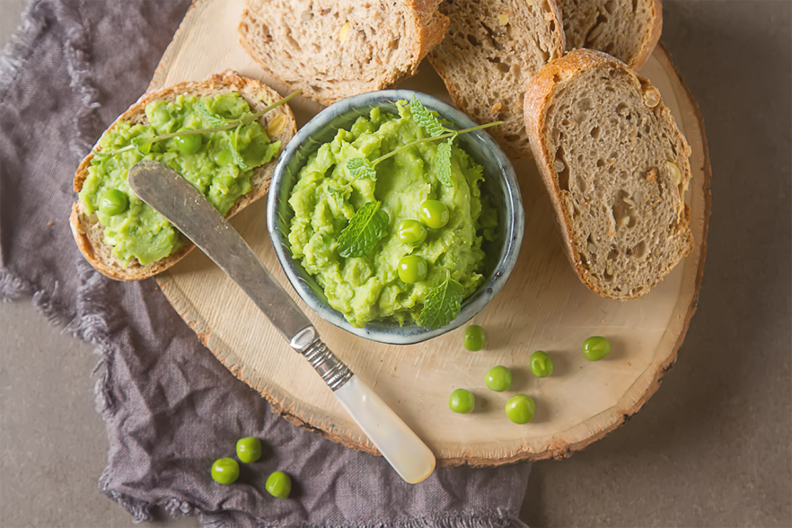 Erbsenaufstrich in kleiner Schale neben Baguette Foto: AdobeStock_naltik