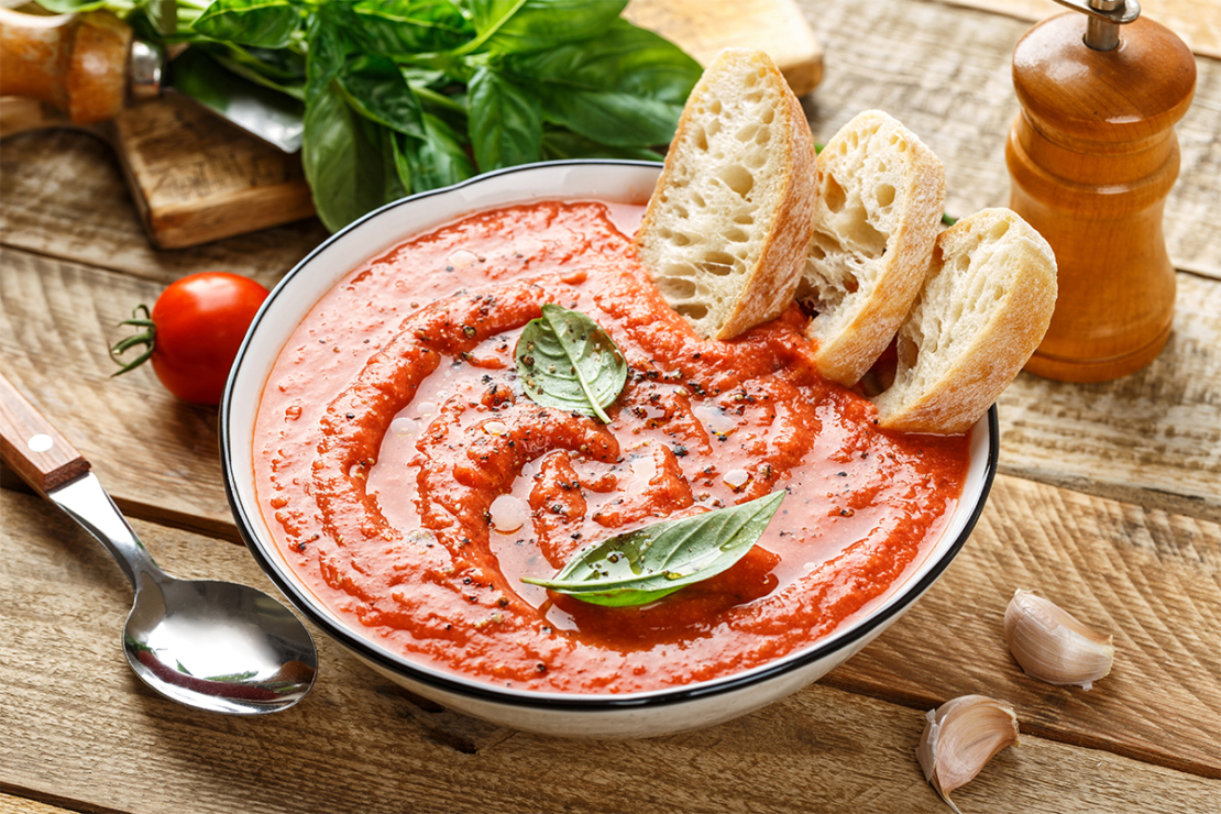 Gazpacho in einer Suppenschale mit drei Scheiben Baguette Foto: AdobeStock_Sunny Forest