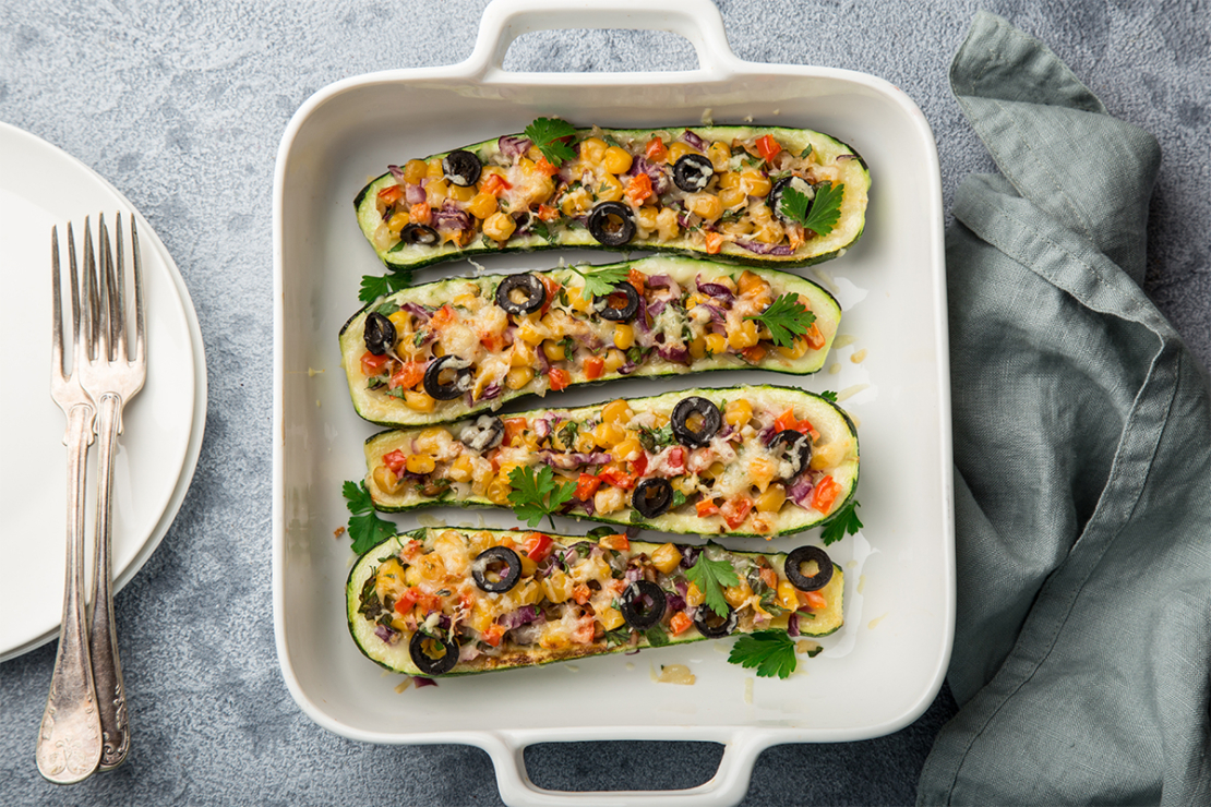 Gefüllte Zucchini mit Oliven, Tomaten, Paprika und roten Zwiebeln in einer Auflaufform Foto: AdobeStock_anna_shepulova-