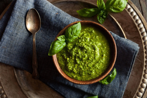 Basilikum-Pesto in Schale auf grauem Leinentuch [Foto: AdobeStock_Brent Hofacker]