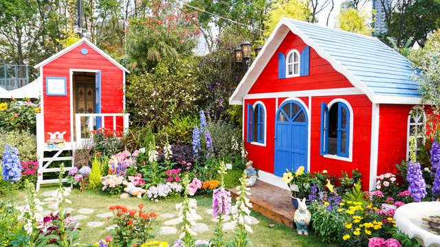 Schrebergarten mit roter Hütte und kleiner Gartenlaube