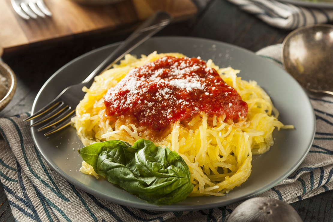 Spaghettikürbis als Nudeln angerichtet mit Tomatensauce und Käse [Foto: AdobeStock_Brent Hofacker]