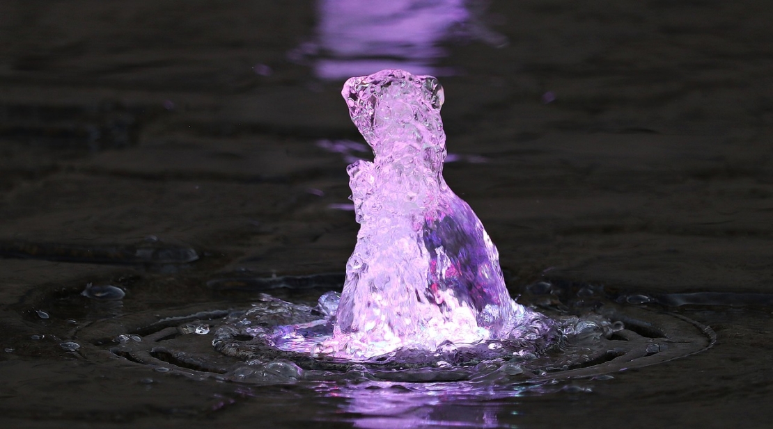 Sprudelndes Wasserspiel mit Beleuchtung in lila