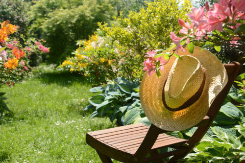 Strohhut auf Holzstuhl im Garten. Foto: AdobeStock_K.-U. Häßler