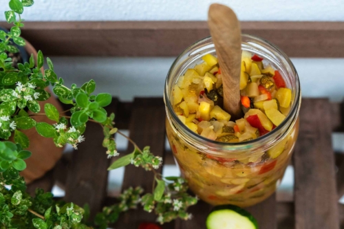 Zucchini Chutney im Glas auf Holztisch [Foto: AdobeStock_Jana Lösch]