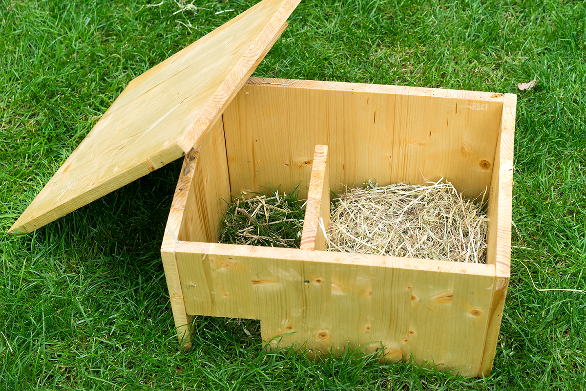 Igelhaus aus Holz mit Trennwand auf einem Rasen bauen [Foto: AdobeStock_Irottlaender]