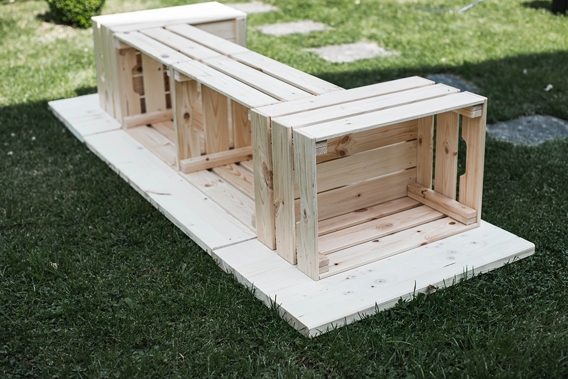 Mittelteil und Oberkonstruktion einer DIY-Outdoor-Bar aus Holz wurden so auf dem Boden hingelegt, wie sie später montiert werden sollen.