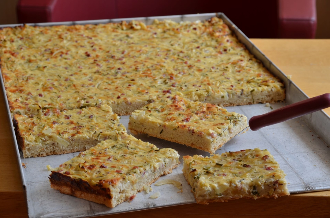 Zu sehen ist ein Blech, auf dem Zwiebelkuchen gebacken wurde.