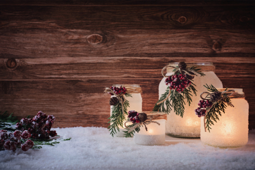 Windlicht basteln und zu Weihnachten mit Sprühschnee und Koniferengrün verzieren [Foto: AdobeStock_Emmi]