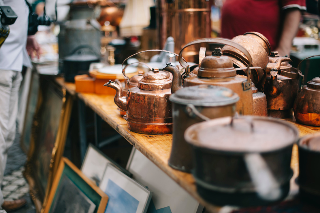 Nachhaltige Weihnachtsgeschenke: Stand auf einem Flohmarkt mit alten Töpfen, Vasen und gerahmten Bildern. Foto: AdobeStock_anastasianess