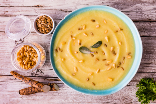 Schwarzwurzelsuppe mit Pinienkernen auf einem Tisch [Foto: AdobeStock_iMarzi]