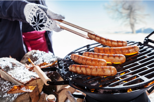 Wintergrillen mit Würstchen auf einem Kugelgrill [Foto: AdobeStock_Exclusive-Design]