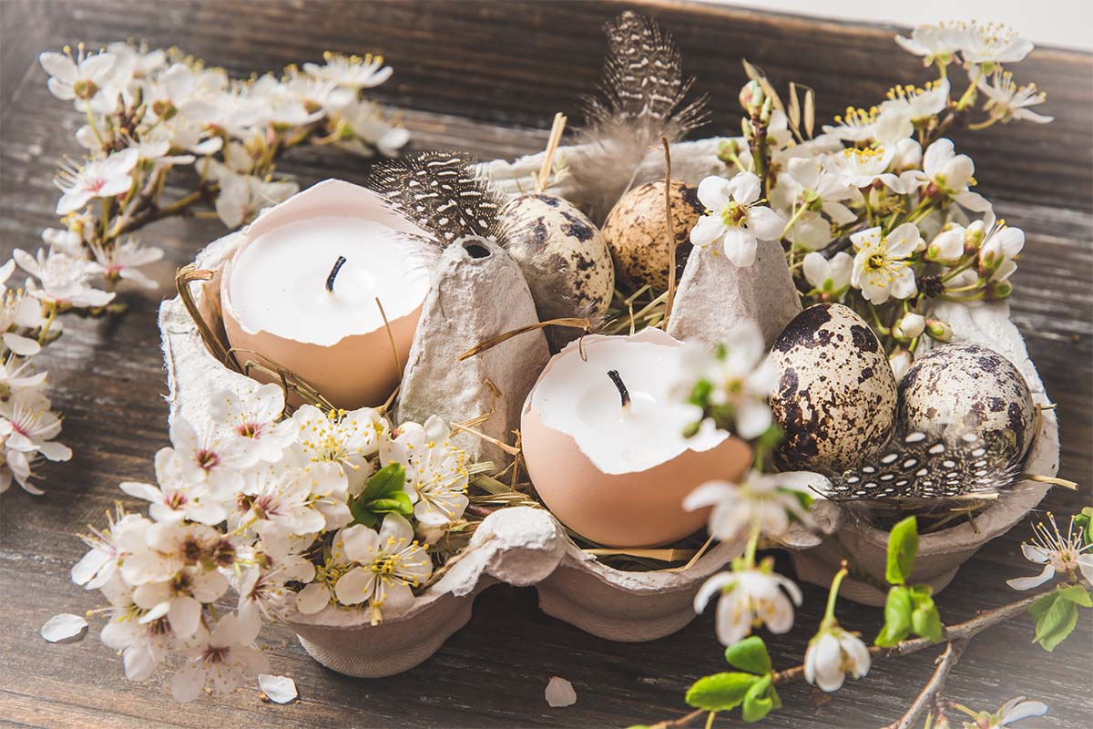 Basteln mit Eierschalen: Arrangement mit Kerzen und Wachteleiern in einem Eierkarton [Foto: AdobeStock_Daniela Baumann]