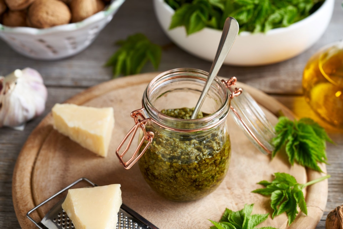 Nicht nur Spinatpesto schmeckt. Auch Giersch-Pesto ist eine Probe wert. Hier zu sehen ist ein Pestoglas, neben Parmesan und Nüssen. [Foto: AdobeStock_Madeleine-Steinbach]