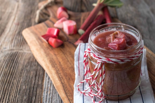 Rhabarberkompott in einem Einmachglas auf einem Holztisch [Foto: AdobeStock_Angelika Heine]