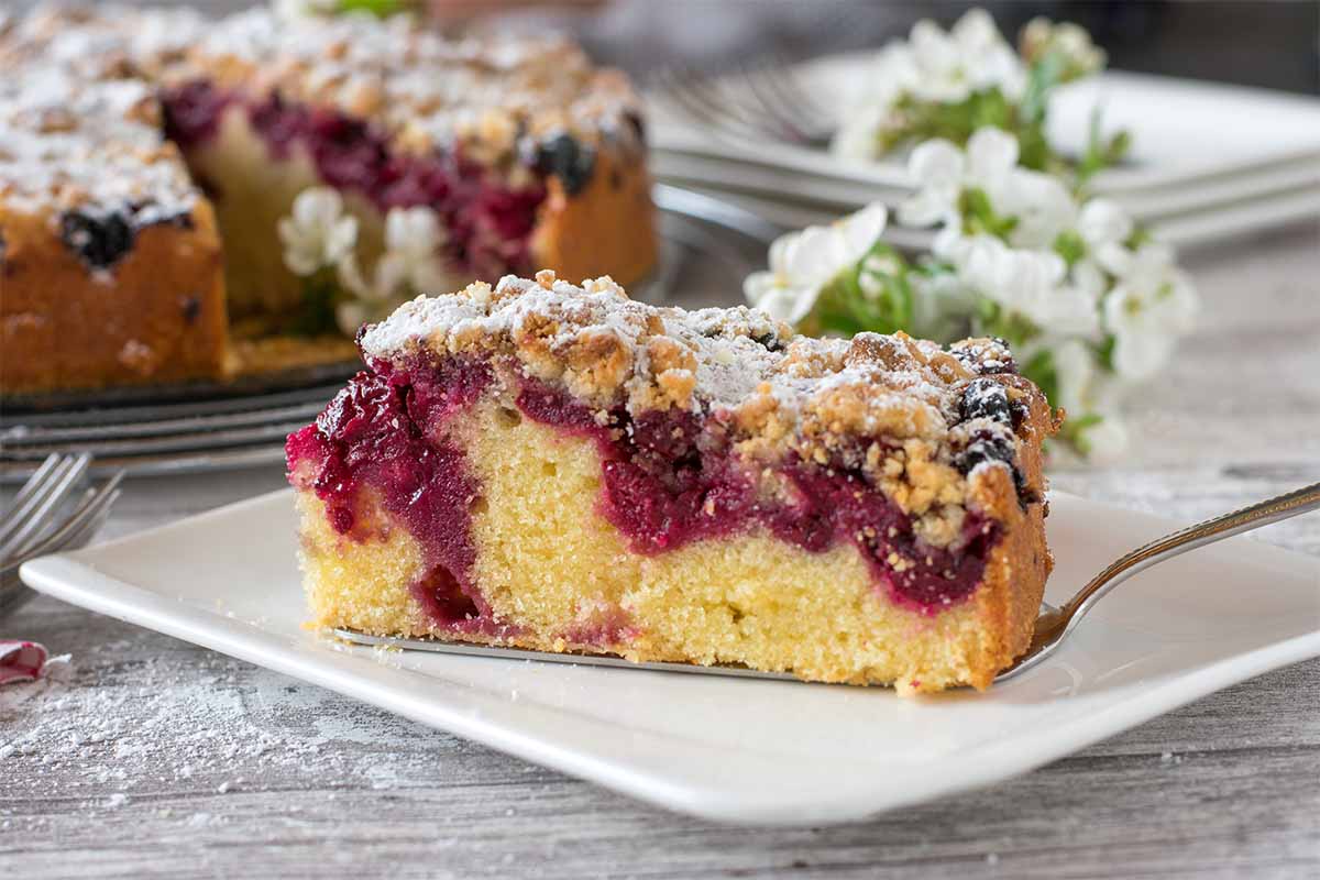 Ein Stück Kirschkuchen auf dem Gartentisch [Foto: AdobeStock_Angelika Heine]