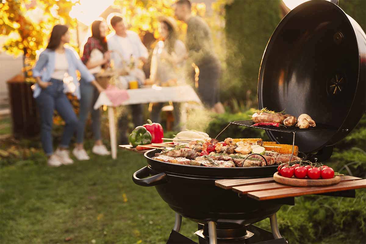 Grill steht mit Grillgut auf einer Grillparty [Foto: AdobeStock_New Africa]