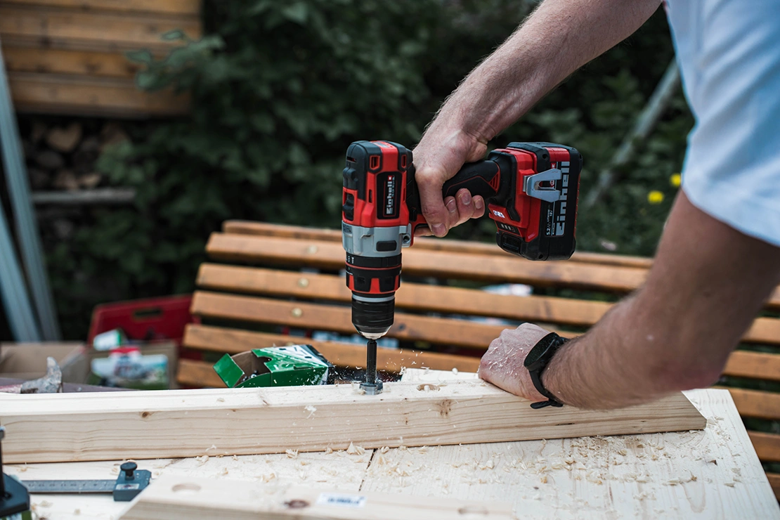 Outdoor-Bar konstruieren: Ein Mann bohrt Löcher in eine Holzlatte. Foto: Einhell