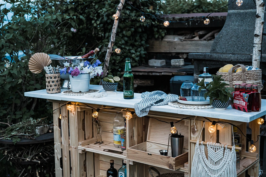 Dekorierte Outdoor-Bar in der Abenddämmerung im Garten.