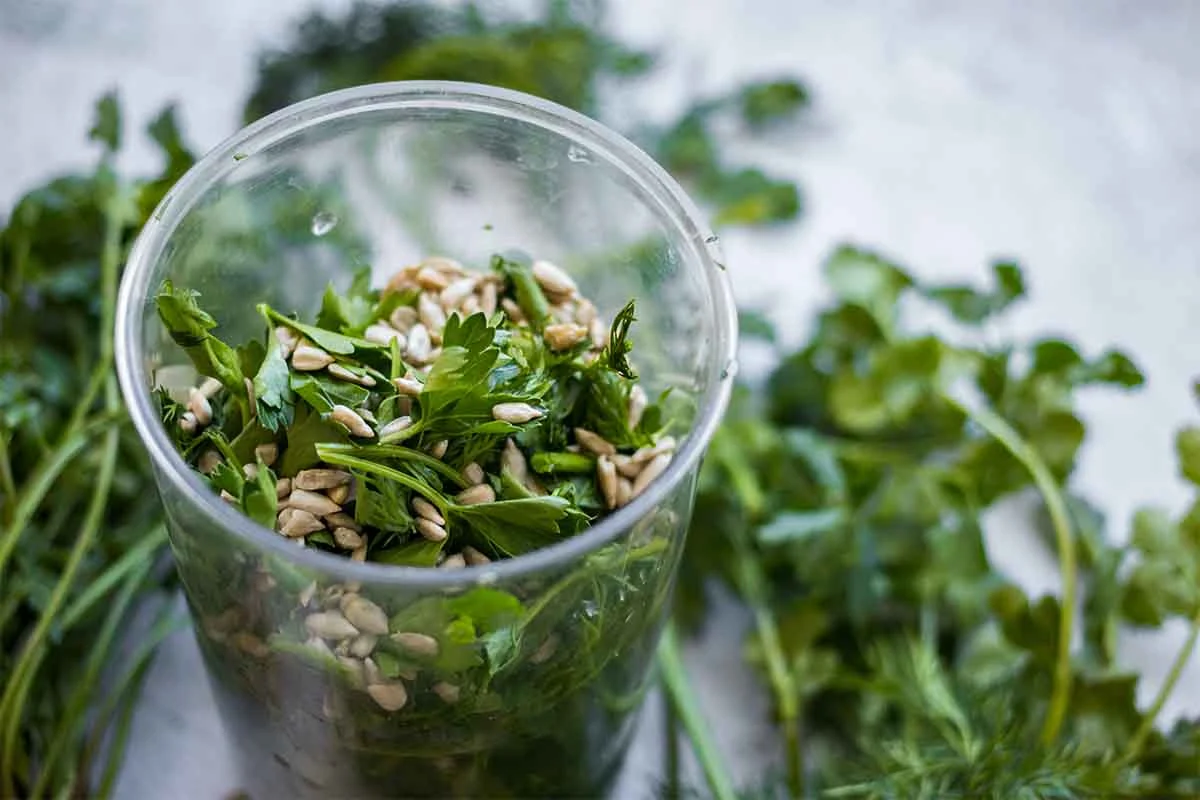 Zutaten fuer ein Kraeuterpesto vor dem Mixen in einem Glas [Foto: AdobeStock_Viktor Kochetkov]