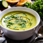 Zucchinisuppe angerichtet in einer Schale auf einem Esstisch [Foto: AdobeStock_Jacek Chabraszewski]