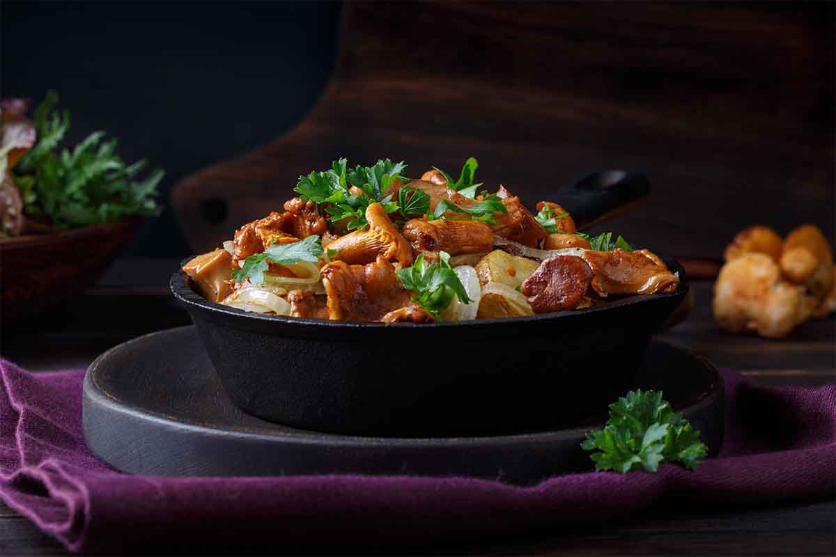 Diese Pilzpfanne wird in einer gusseisernen Pfanne serviert und mit Petersilie serviert [Foto: AdobeStock_geshas]