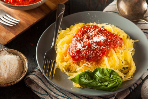 Gekochter und zu Nudeln bereiteter Spaghettikürbis auf einem grauen Teller [Foto: AdobeStock_Brent-Hofacker]