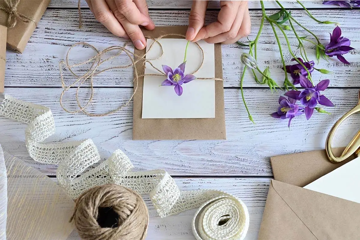 Als Valentinstagsgeschenk wird eine Karte aus braunem Karton selber gemacht und mit lila Blumen verziert