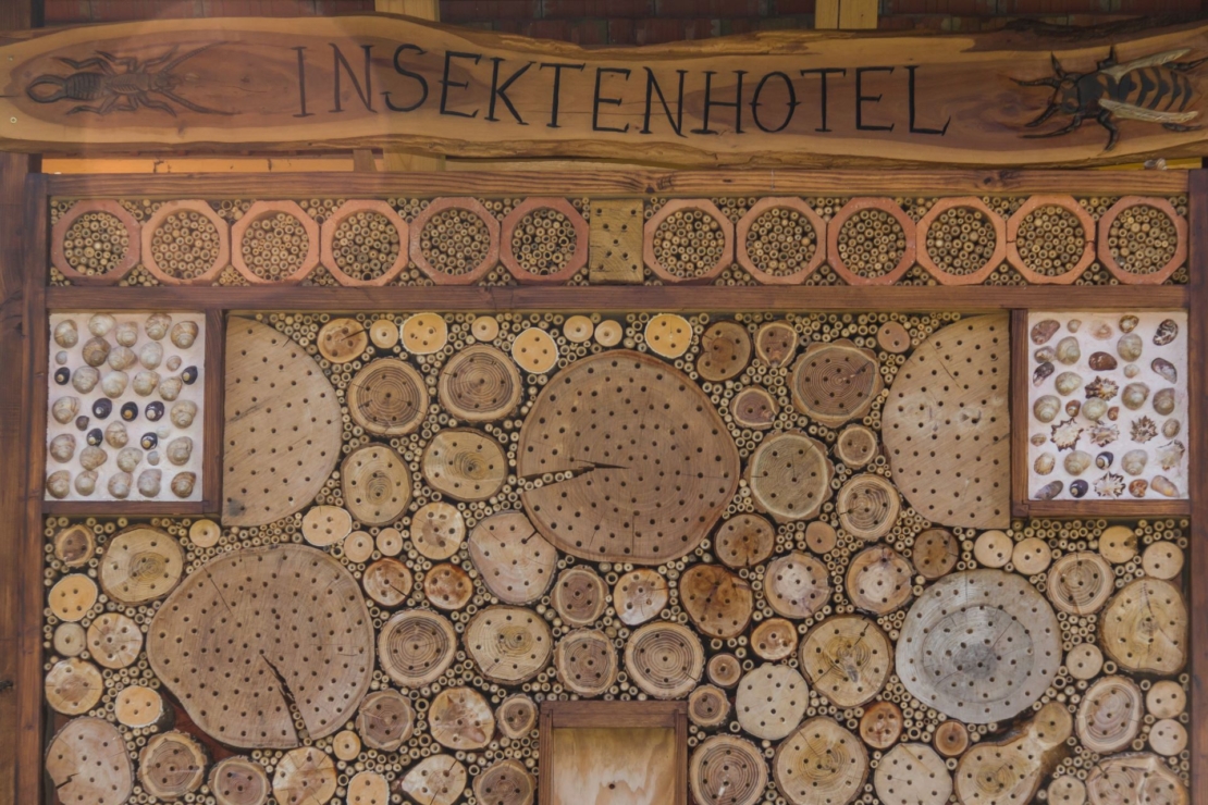 Großes Insektenhotel mit vielen Holzscheiben mit Schlupflöchern.