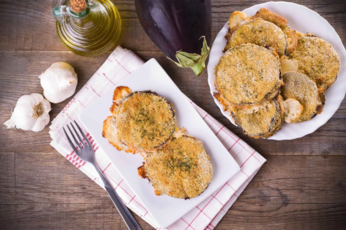 Auberginenschnitzel auf einem Teller und einer Servierplatte [Foto: AdobeStock_Mi.Ti.]
