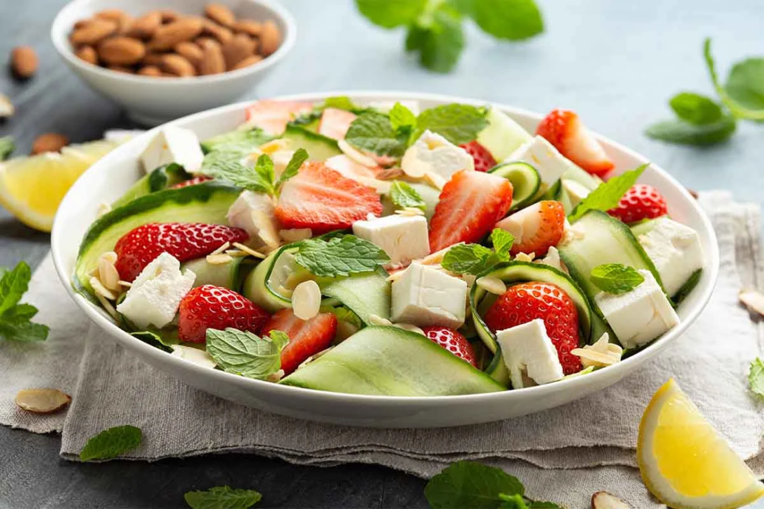 Sommersalate wie hier mit Gurke, Erdbeeren und Hirtenkaese [Foto: AdobeStock_Grinchh]